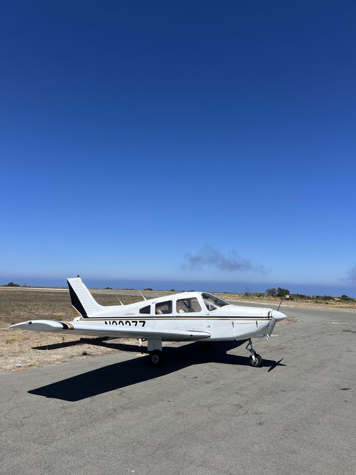 N2227Z, a Piper Warrior II, parked with the Pacific in the background