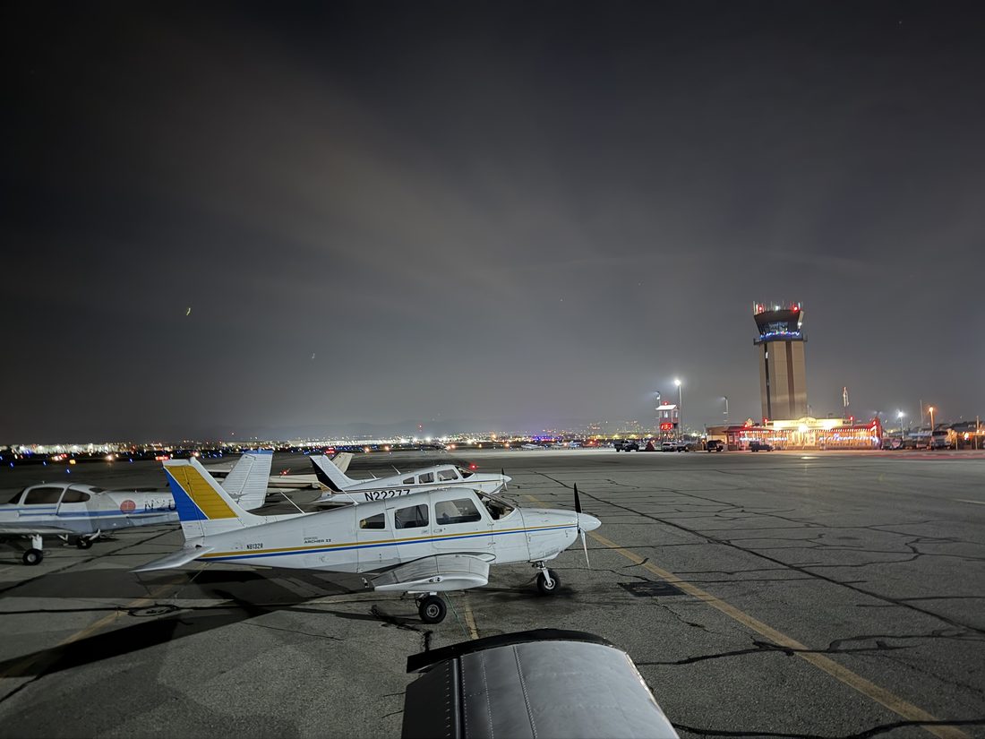 N8132R and N2227Z parked at night with the Chino Airport tower lit in the background